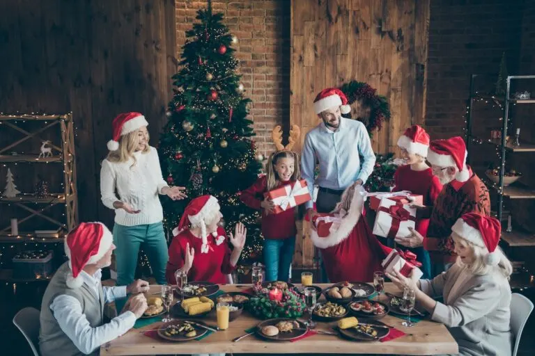 Photo of large family with small little kids senior pensioner sit table, on x-mas meal celebration in santa claus cap hat get receive wish gift boxes house having x-mas tree atmosphere spirit.
