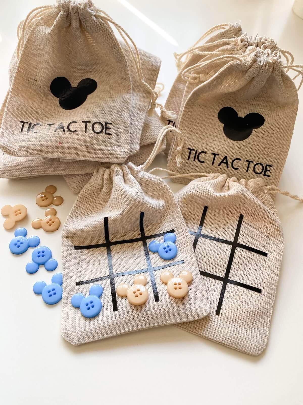 Diy cricut tic tac toe bags with mickey shaped buttons.