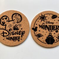 two laser engraved cork coasters with disney wonder images.