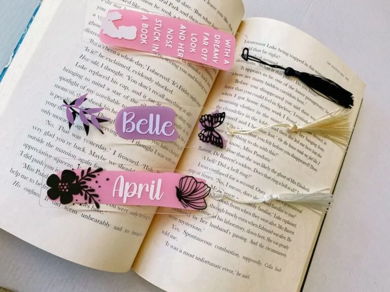 3 personalised acrylic bookmarks resting inside an open book.