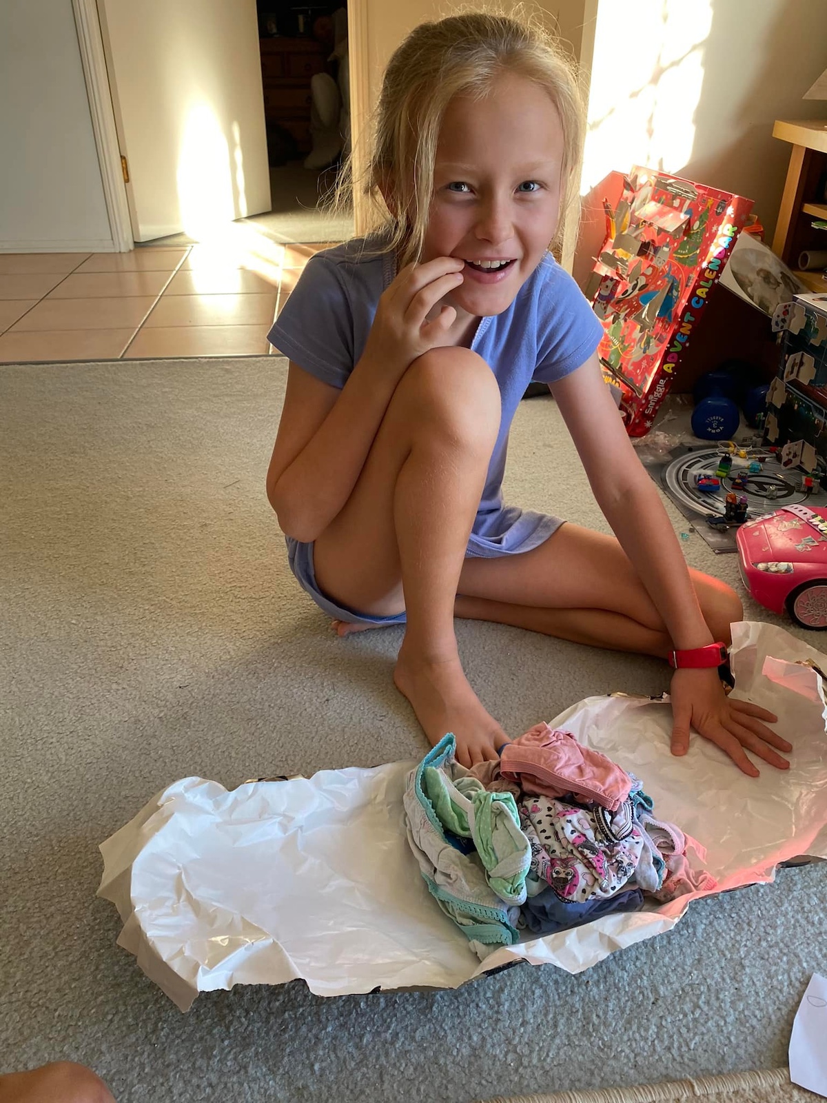 Little girl unwrapping prank gift from her elf.