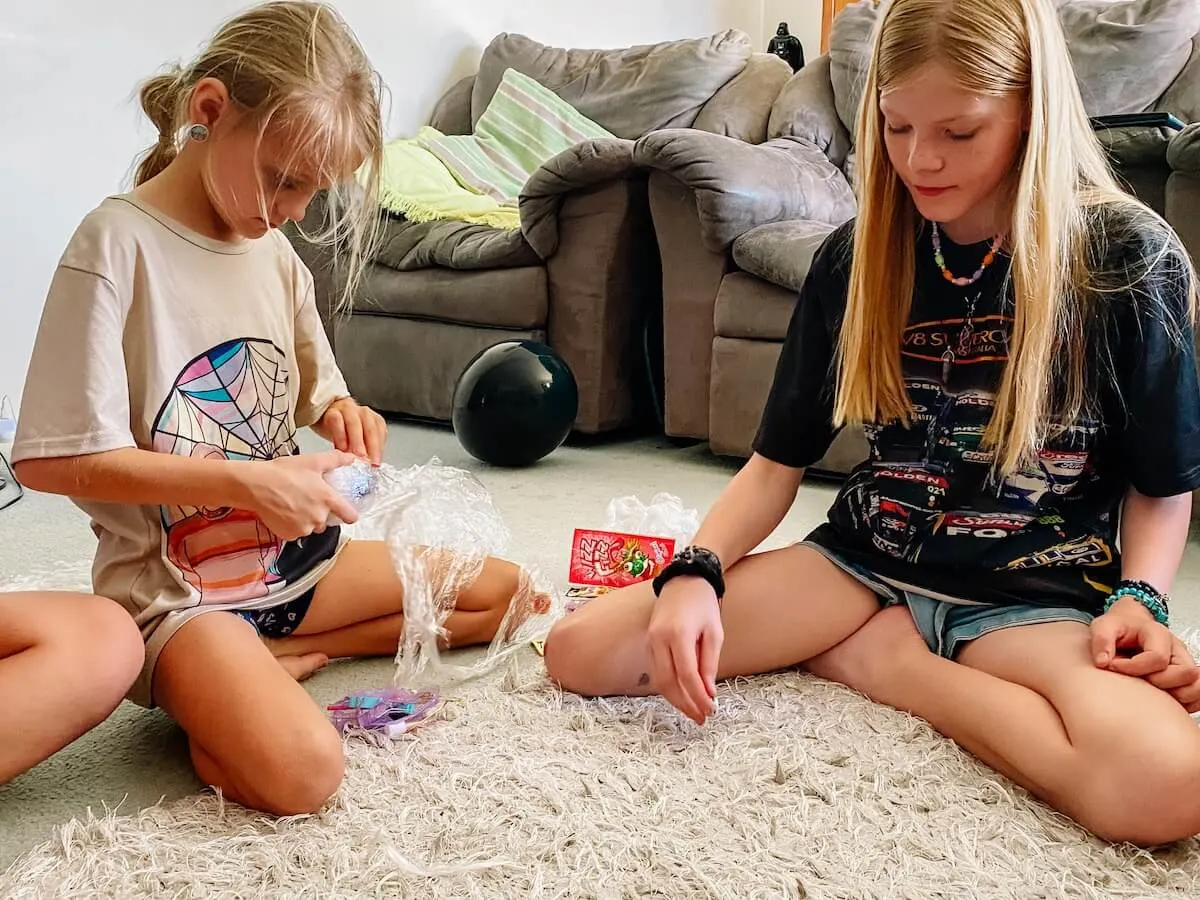 Kids playing the saran wrap ball game on the floor at a birthday party.