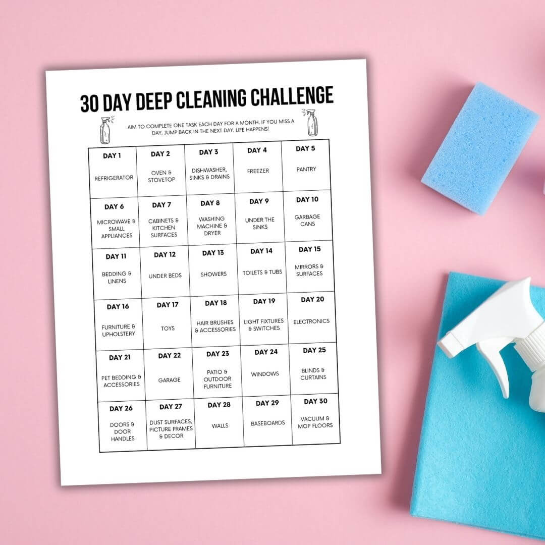 30 day cleaning challenge printable on pink background with cleaning supplies.