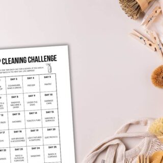 printable 30 day deep cleaning challenge sitting next to a pile of cleaning supplies.