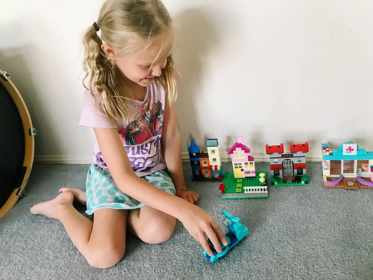 Little girl building a lego city.