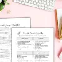 sunday reset routine checklist and weekly reset ideas printables on pink background with desk items and folliage.