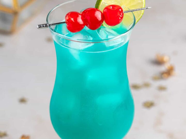 blue hurricane cocktail with cherries.