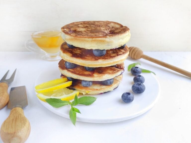 stack of blueberry lemon pancakes on white plate.