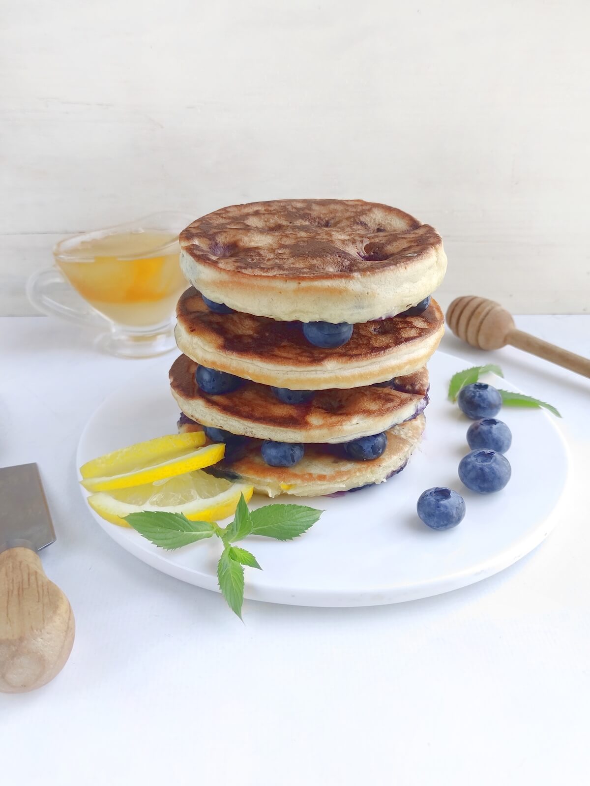 stack of blueberry pancakes on white plate.