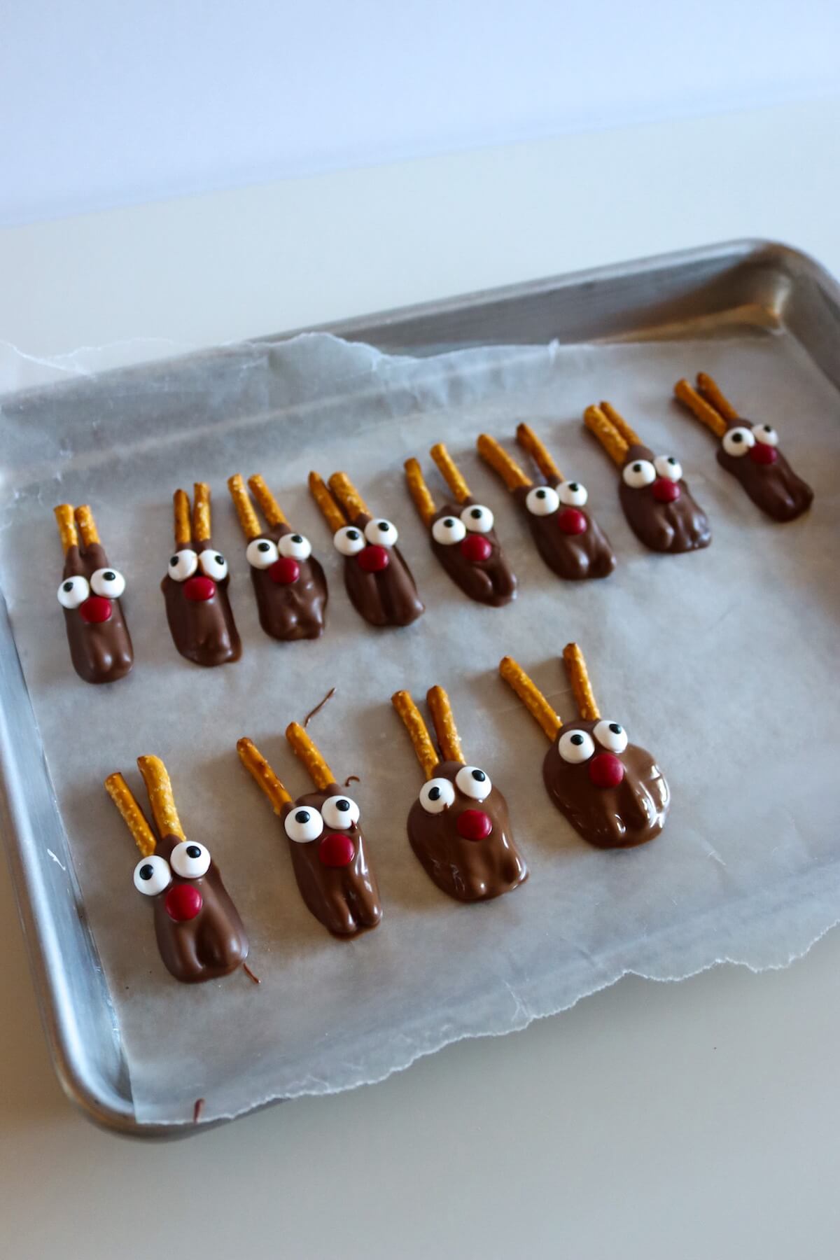 No-Bake Pretzel Reindeers 4 pretzel reindeers on tray.
