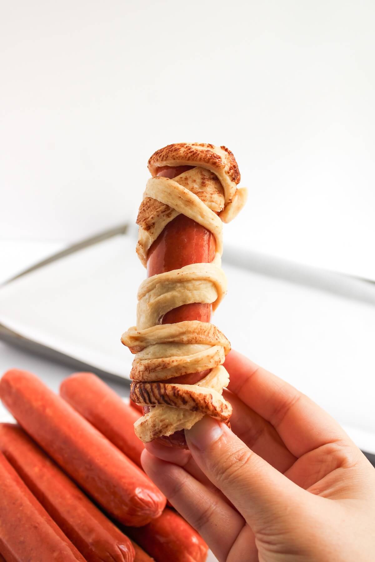 Halloween Mummy Sausages 6 wrapping crescent dough around sausages.