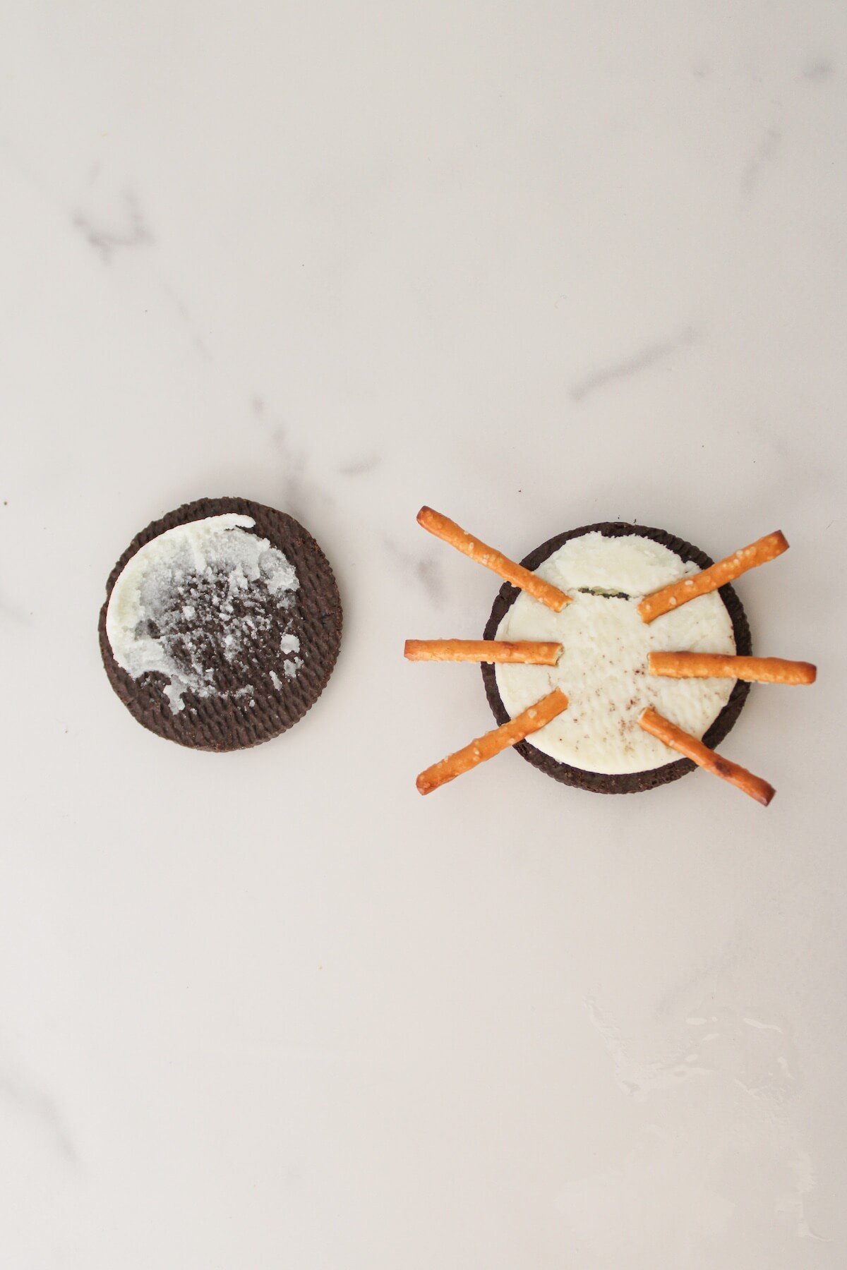 making oreo spider cookies with pretzel legs.