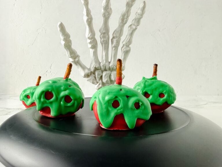 Apple marshmallow Halloween treat on a black tray.